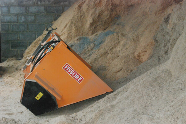 Sawdust spreader resting on the side of the sawdust pile