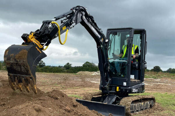 Black excavator with a tiltrotator and bucket attached.
